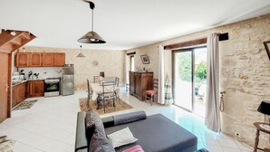 A spacious living area with a sofa, a dining table, and a kitchen in the background. - Lovely home in Paulin with kitchen (Paulin)