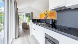 A modern kitchen with a black countertop, stainless steel sink, and a Bosch range hood. - Luxurious home in Voorthuizen with WiFi (Voorthuizen)