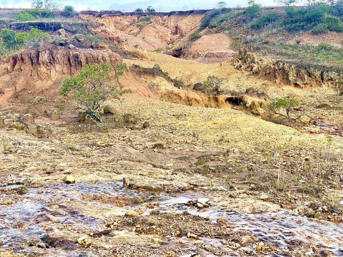 A rugged landscape with a river flowing through a dry, rocky terrain.
