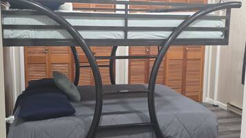 Un letto a castello con struttura circolare, testiera in legno e materasso grigio.