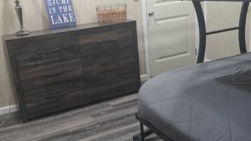 A bedroom with a bunk bed, a dresser, a lamp, and a sign on the wall.