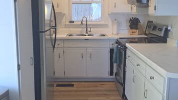 A kitchen with white cabinets, a stainless steel sink, and a built-in oven.
