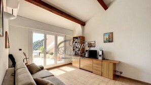Een ruime woonkamer met een bank, een televisie en een houten kast.