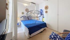 A bedroom with a bed, a wardrobe, a desk, and a chair.