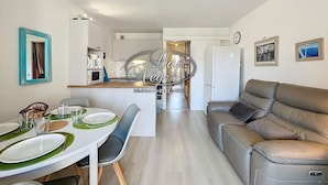 A compact living space with a dining area, kitchenette, and a sofa.