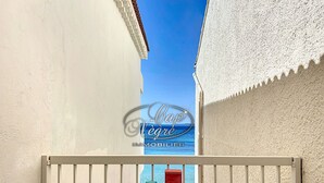 A balcony with a table set for two, a red box, and a green cup. - Modern studio with sea view and direct access to Cavalière Beach (Le Lavandou)