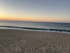A beach with a sandy shore and waves approaching the beach. - Charming 1-bedroom apartment w/ Purified Water, AC and WiFi in San José del Cabo (San José del Cabo B.C.S.)