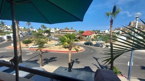 A street view with palm trees, cars, and buildings. - Charming 1-bedroom apartment w/ Purified Water, AC and WiFi in San José del Cabo (San José del Cabo B.C.S.)