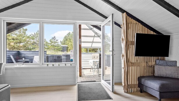 Een moderne, open woonruimte met een grote schuifpui naar een terras.