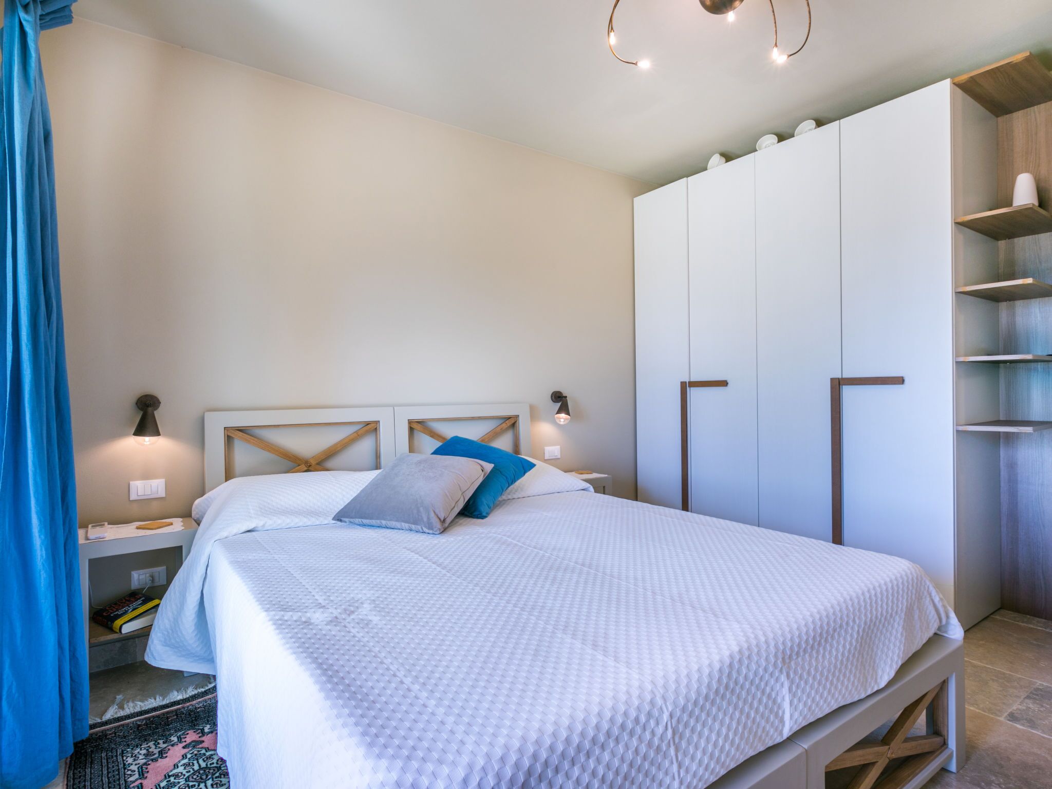 Une chambre à coucher comprenant un lit, des tables de chevet, une armoire et une commode.