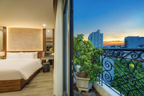 Une chambre d’hôtel avec un grand lit, une table de chevet, une lampe et une plante en pot.