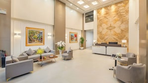 A spacious lobby with a reception desk, sofas, and a coffee table. -  Gilson Hanoi Hotel (Hanoi)