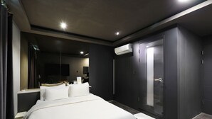 Quarto de hotel moderno com uma cama grande, um closet espaçoso e um aparelho de ar condicionado.