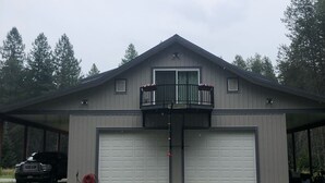 En tvåvåningsbyggnad med ett garage och en överbyggd uppfart.