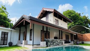 A two-story house with a swimming pool, featuring a covered patio and a large window. - Thaprobana Villa Tangalle Private Villa (Tangalle)