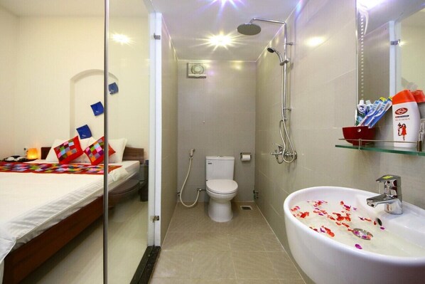 A compact hotel bathroom with a shower, toilet, and sink. - An Vien Hotel (Da Nang)