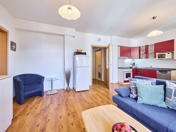 A compact living space with a kitchenette, a dining area, and a sofa.