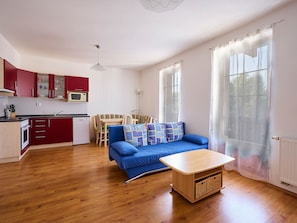 Cozy living space with a kitchenette, sofa, and table.