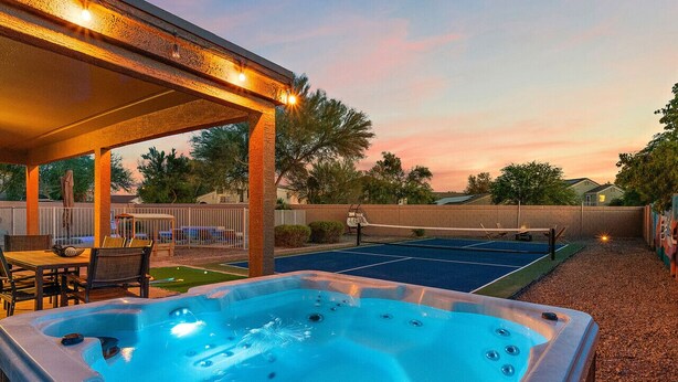 A hot tub with a wooden deck and a covered seating area.