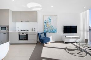 A modern kitchen with a Bosch oven, a coffee maker, and a kettle on the countertop. - Stunning High Level Deluxe Apartment at Rhapsody (Surfers Paradise)