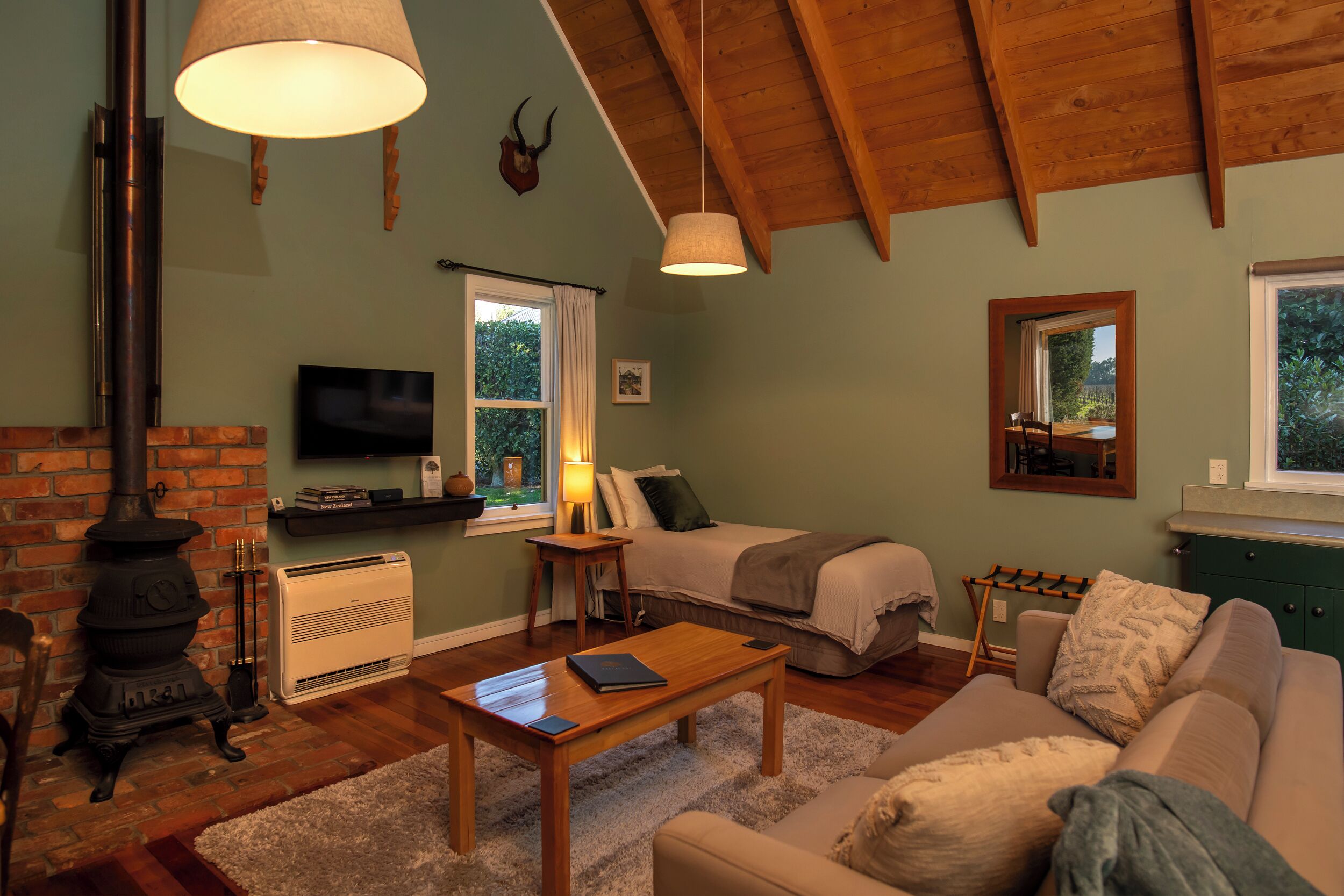 A cozy living room with a fireplace, a sofa, a coffee table, and a TV.