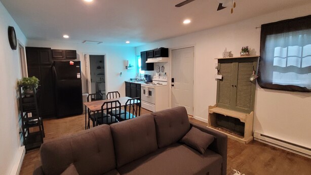 A compact living space with a sofa, dining table, kitchen area, and a ceiling fan. - Charming 1-bd house in Downtown Farmington, 1block from Police & Fire stations (Farmington)