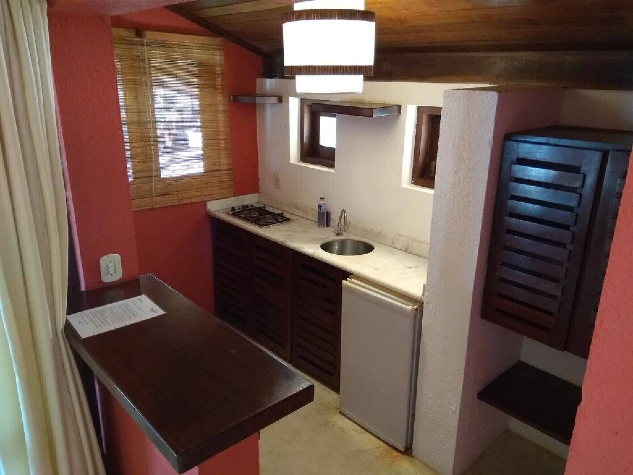 A compact kitchen with a gas stove, sink, and a small refrigerator.