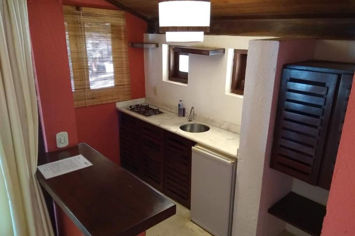 A compact kitchen with a gas stove, sink, and a small refrigerator.