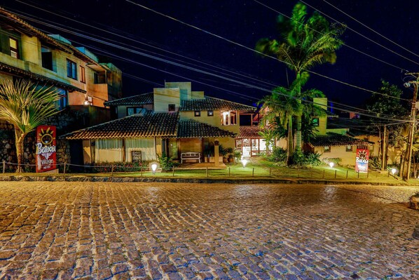 Una calle adoquinada que lleva a un edificio con tejado de azulejos y un letrero que indica un hotel.