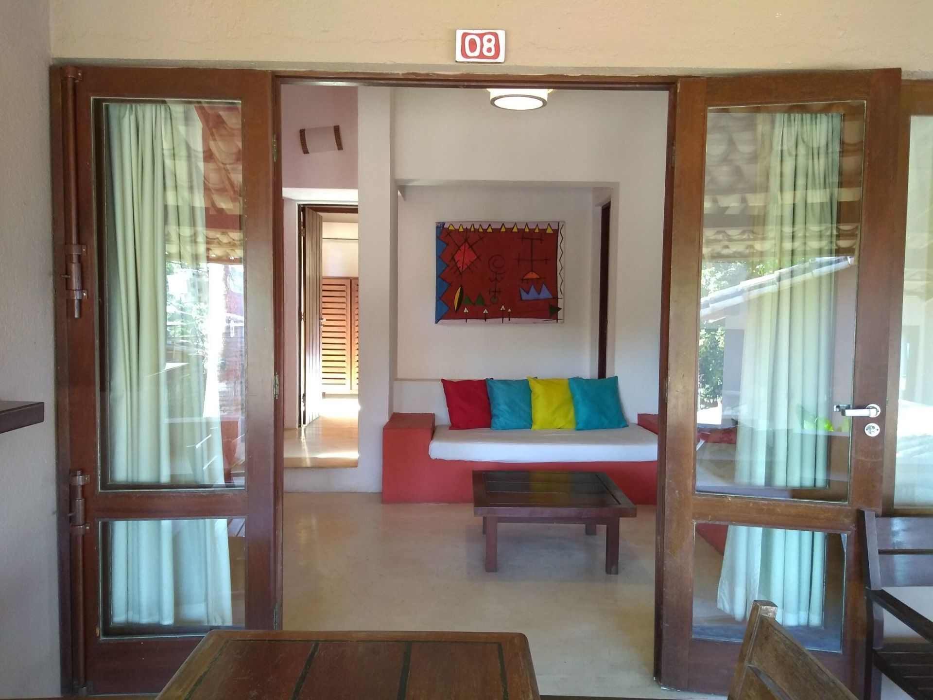 A room with a sofa, a table, and a wall-mounted artwork.