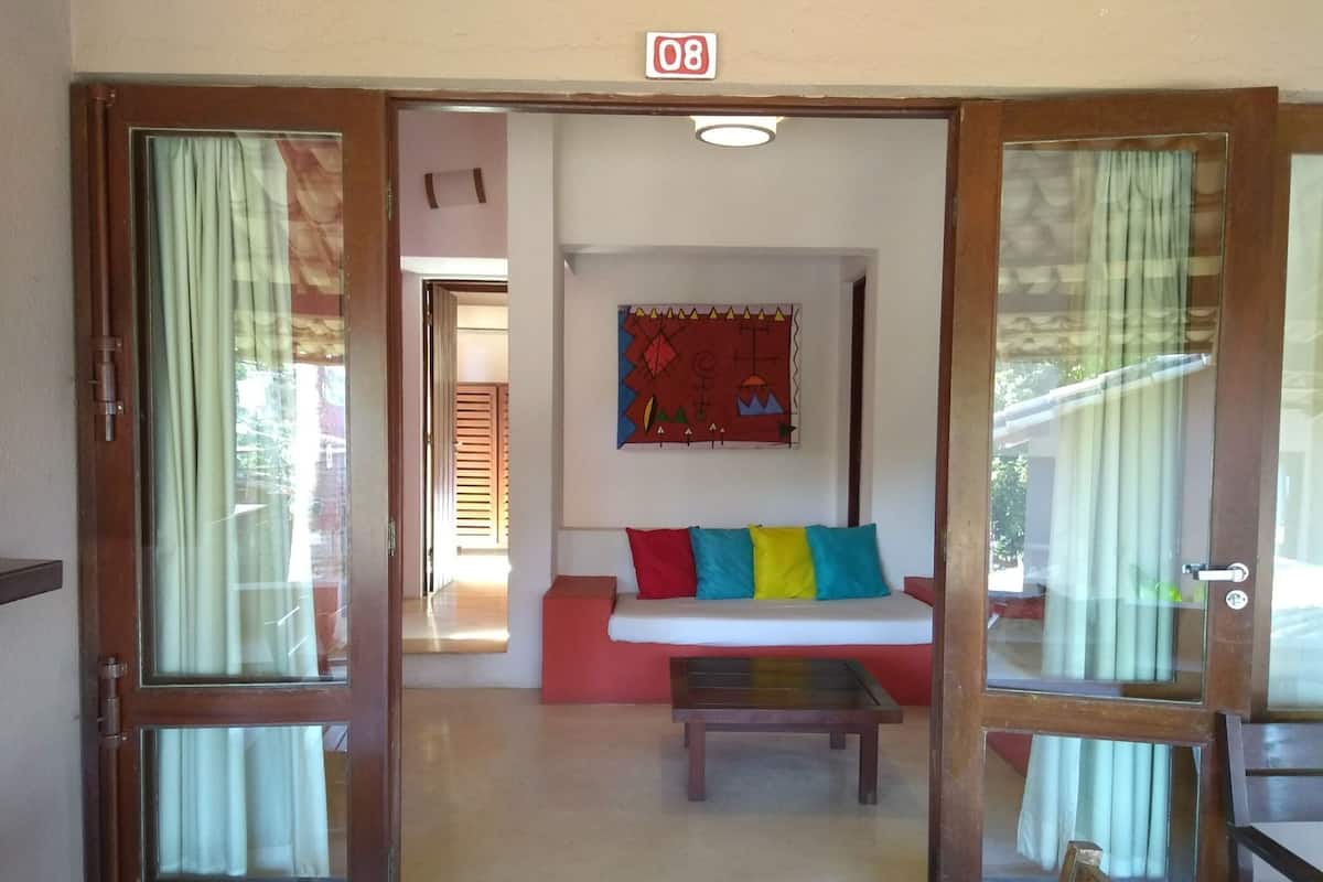 A room with a sofa, a table, and a wall-mounted artwork.
