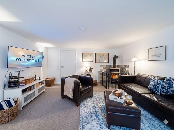 A living room with a fireplace, a sofa, a television, and a coffee table.