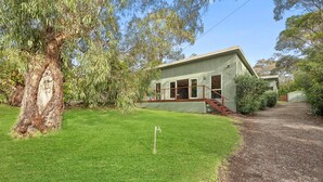 A single-story building with a front porch, a small staircase, and a well-maintained lawn. - Surphy G (Anglesea)