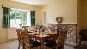 Un comedor con chimenea de piedra, una decoración con forma de corazón y vistas al exterior.