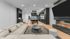 Una sala moderna con un sofá modular, una mesa de centro redonda y una chimenea.