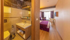 A hotel room with a bathroom, a bed, a desk, and a chair. - Interstellar Hotel (Istanbul)