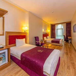 A hotel room with two beds, a desk, a chair, and a minibar. - Interstellar Hotel (Istanbul)