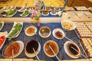 A buffet table with various food items and condiments. - Interstellar Hotel (Istanbul)