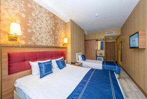 A hotel room with two beds, a red headboard, and a television on the wall. - Interstellar Hotel (Istanbul)