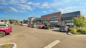 A parking lot with several cars, a building labeled "Black Belt Karate," and a "Junior Rental" sign. - Cozy Place to Stay in South Calgary (Calgary)