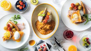 A breakfast setting with various dishes including pancakes, eggs, and fruits.