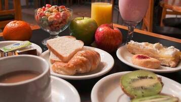 Un desayuno con diversas opciones de comida y bebidas.