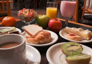 Une table dressée pour le petit-déjeuner, avec divers aliments et boissons.