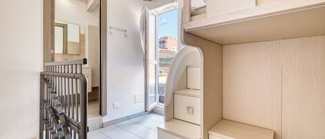 Ein moderner, gut beleuchteter Flur mit einer Treppe, einem Holzschrank und einem Spiegel.