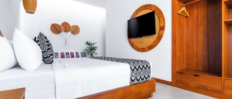 Une chambre à coucher moderne avec un lit, un téléviseur fixé au mur, une armoire en bois et un luminaire suspendu.