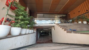 Un couloir étroit orné de plantes en pot, un escalier et une enseigne de restaurant bien visible.