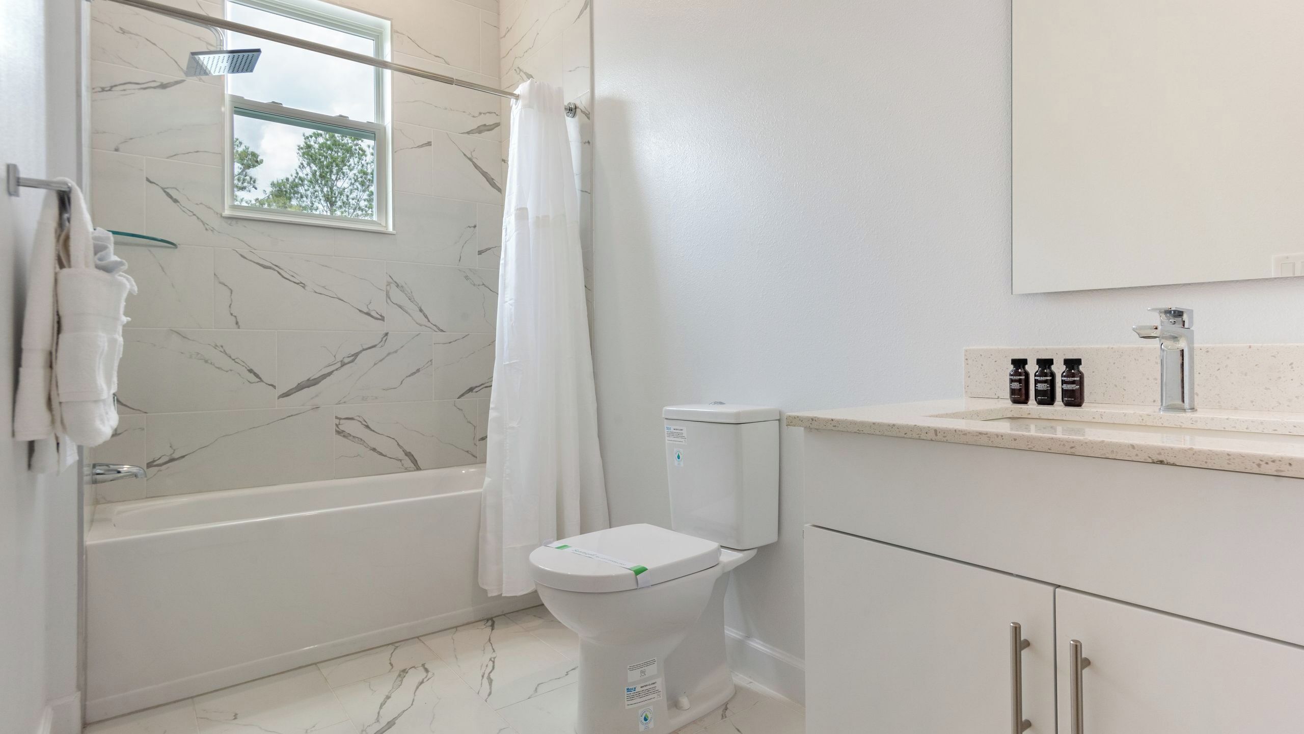 Une salle de bain avec une douche, des toilettes et une fenêtre.