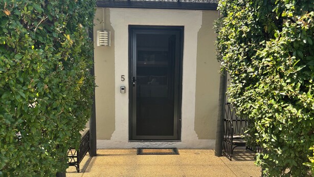 A building entrance with a black door, number 5, and a metal gate. - Pirathon Country Estate (Tanunda)