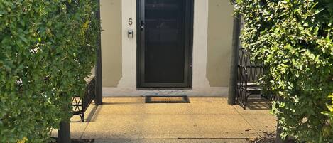 A building entrance with a black door, number 5, and a metal gate.