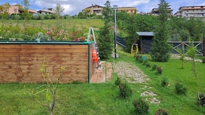 A garden with a wooden structure, a paved path, and a small shed.